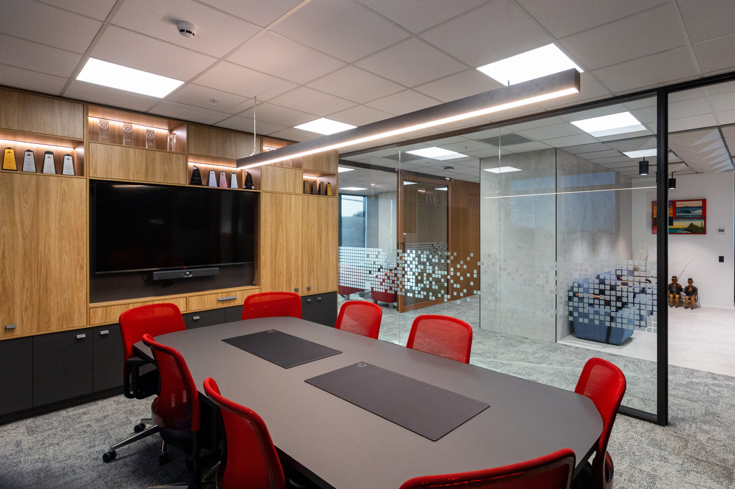 Modern boardroom with a large meeting table, comfortable seating, and presentation facilities.